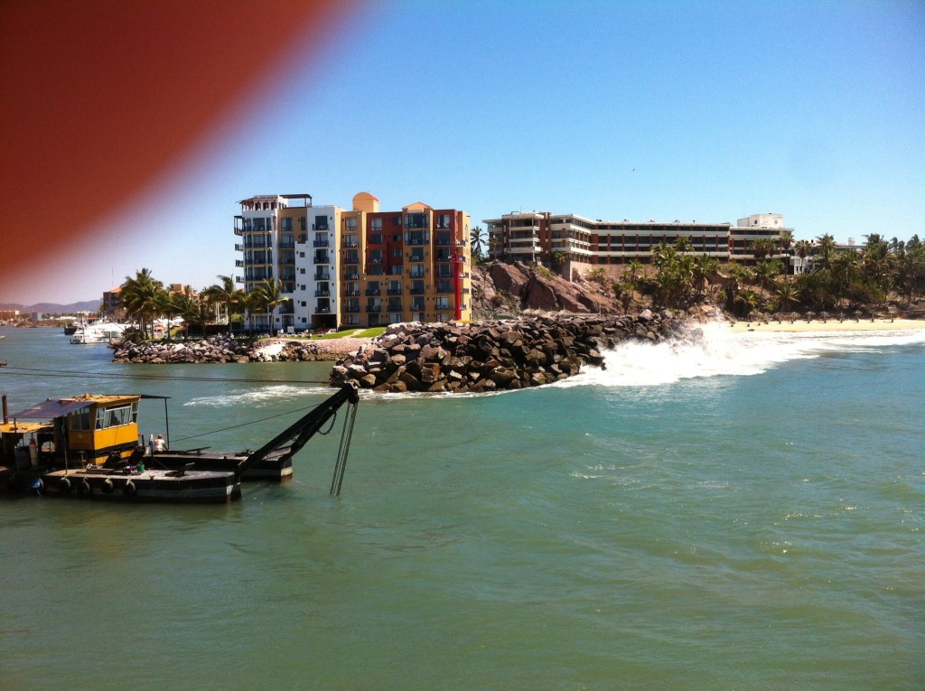 The dredge partially blocking the channel entrance, forcing boats over towards the breakwater where boaters must power through to combat the force of breaking waves to the south.